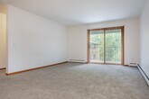 Located at 72 Kessel Ct in Madison, Wisconsin, this single-floor, one-bedroom, one-bathroom home offers a well-organized and functional layout. A welcoming hallway connects the main living areas, which feature neutral-toned carpet, warm wood baseboard trim, and baseboard heating throughout.

The spacious living room is bathed in natural light from a wood-framed window with views of lush surrounding trees, creating a bright and comfortable atmosphere. The kitchen is well-equipped with warm oak cabinetry, light countertops, and black appliances including a refrigerator, electric range, and dishwasher, all set on easy-care hard surface flooring.

The generously sized bedroom includes a ceiling fan with light fixture, a window for natural light, and access to ample closet space — three closets are distributed throughout the home for excellent storage. The full bathroom features a combined tub and shower, a vanity with oak cabinetry, and hard surface flooring.

A dedicated in-unit laundry room comes equipped with a full-size washer and dryer, plus built-in shelving for added convenience. The home also includes a private patio, offering an outdoor retreat. Clean, neutral finishes and a practical floor plan make this a comfortable and move-in ready residence.