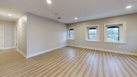 Located at 888 Delaware Ave in Buffalo, NY, this thoughtfully updated single-floor residence offers three bedrooms, two bathrooms, a living room, a kitchen, a laundry area, and two hallways — all finished with consistent, contemporary details throughout. Light wood-tone luxury vinyl flooring runs seamlessly across every room, complemented by neutral gray-beige walls and crisp white trim and baseboards that create a clean, cohesive aesthetic. The kitchen is outfitted with white shaker cabinetry, light stone-look countertops, and stainless steel appliances including a range, microwave, and dishwasher. It opens directly into the living area, promoting an easy flow between spaces. The hallways are bright and well-proportioned, with recessed lighting guiding the way to the bedrooms and bathrooms. The bedrooms are comfortably sized, with the primary bedroom offering dedicated closet access and natural light from street-facing windows. The bathrooms are finished with light flooring, a glass-enclosed shower, and frosted privacy windows. A dedicated laundry and utility area houses a tankless water heater and furnace, offering efficient, modern mechanical systems. Recessed lighting throughout the main areas ensures a bright, welcoming ambiance at all hours.
