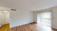 Located at 3070 Kelly Cir in Montgomery, Alabama, this one-bedroom, one-bathroom unit offers a practical and comfortable single-floor layout. Warm hardwood-style flooring flows throughout the living areas, complementing the bright, neutral walls and textured ceilings found across the space.

The living room is generously proportioned, bathed in natural light through a large sliding glass door that opens to a private balcony, creating a pleasant indoor-outdoor connection. Crown molding adds a subtle decorative touch to the room.

The galley-style kitchen is efficiently designed with dark wood cabinetry lining both sides, light stone-patterned countertops, a stainless steel sink, and white appliances including a refrigerator and electric range. Tile flooring and crown molding complete the kitchen's clean, functional aesthetic.

The bedroom is a comfortable retreat, featuring hardwood-style flooring, a window with outdoor views of surrounding greenery, and an open closet with a full-width hanging rod for ample storage. A textured ceiling adds visual character to the room.

The bathroom includes a full tub-shower combination with classic tile surround and chrome fixtures, maintaining a clean and straightforward design. A connecting hallway ties all rooms together, ensuring a logical and easy-to-navigate floor plan throughout the unit.