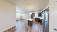 Located at 100 Winghaven Pointe Drive in O'Fallon, Missouri, this single-floor, one-bedroom, one-bathroom residence offers a thoughtfully designed layout with a clean, modern aesthetic. The open-concept living and kitchen area forms the heart of the home, featuring wood-style luxury vinyl plank flooring, neutral walls, and abundant natural light streaming through multiple windows fitted with horizontal blinds. A ceiling fan anchors the living space, which offers direct access to an outdoor balcony area. The kitchen is well-appointed with rich dark espresso cabinetry, crisp white countertops, a tile backsplash, and a full suite of stainless steel appliances including a refrigerator, range, over-the-range microwave, and dishwasher. A central kitchen island provides additional prep and seating space, complemented by pendant lighting overhead. The bedroom is a comfortable retreat featuring plush carpeting, a ceiling fan, and generous natural light from dual windows. A dedicated closet offers practical storage. The bathroom includes a full tub/shower combination with clean white surround and wood-style flooring that ties cohesively into the rest of the home. The overall ambiance is bright, fresh, and move-in ready, making this residence a functional and inviting space.