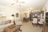 This single-floor residence offers a thoughtfully designed layout that balances comfort and functionality across its living spaces. The living room serves as the heart of the home, featuring plush carpeting, a ceiling fan with integrated lighting, and a window that invites natural light. The open flow connects seamlessly to a dedicated dining area, making the space ideal for everyday living and entertaining.

The kitchen is well-equipped, showcasing rich dark cabinetry with ample storage, granite-style countertops, tile flooring, and a full suite of black appliances including a refrigerator, range, microwave, and dishwasher. The layout maximizes counter space and functionality.

The residence includes multiple bedrooms, each finished with soft carpeting, ceiling fans, and windows fitted with horizontal blinds. The rooms offer generous proportions suitable for full-sized furniture arrangements.

The bathroom features coordinating dark wood cabinetry, a single vanity, tile flooring, and a walk-in shower enclosed with glass doors, providing a clean and practical design. Additional overhead cabinet storage enhances the utility of the space.

Throughout the residence, a neutral warm color palette creates a cohesive and inviting ambiance, complemented by consistent finishes that lend a polished, move-in-ready appeal.