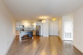 Located at 2900 Main Line Blvd in Alexandria, VA, this 2-bedroom, 3-bathroom residence offers a well-designed, single-floor layout with a clean, modern aesthetic throughout. The open-concept living and kitchen area serves as the heart of the home, showcasing warm hardwood-style flooring, neutral walls, and pendant lighting that creates an inviting atmosphere. The kitchen is outfitted with stainless steel appliances, including a refrigerator, stove, and microwave, complemented by a mosaic tile backsplash, white upper cabinetry, wood-toned lower cabinets, and a freestanding island with a sleek dark countertop — ideal for both meal prep and casual dining. The living area is bright and open, with a pendant light fixture and access to a private balcony through sliding glass doors, bringing in natural light and outdoor views. The primary bedroom offers a comfortable footprint with sliding door balcony access, while the second bedroom features plush carpeting and multiple windows overlooking the exterior. The three bathrooms are finished in a contemporary style — one featuring a glass-enclosed walk-in shower with wood-toned cabinetry and dark countertops, and another with a soaking tub surrounded by clean white tile. Two closets provide ample storage throughout the residence.