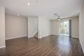 Located in Chula Vista, CA, this well-appointed three-bedroom, five-bathroom home spans three thoughtfully designed floors. The entry-level garage features concrete flooring, overhead storage shelving, an electrical panel, and direct interior access, along with a utility area for added convenience. Carpeted staircases with clean white railings connect each level, establishing a cohesive flow throughout the home. The main living floor offers an open layout with warm wood-look flooring that extends into a modern kitchen equipped with light wood cabinetry, stainless steel appliances including a gas range, microwave, dishwasher, and refrigerator, complemented by a marble-style tile backsplash. A dedicated laundry room houses a full-size washer and dryer with overhead shelving. The upper floor accommodates all three bedrooms, each finished with plush carpeting and neutral tones. The primary bedroom includes a well-organized walk-in closet with built-in shelving and hanging rods. Bathrooms are clean and functional, featuring tub-shower combinations with wood-toned cabinetry. Two balconies extend the living space outdoors, while a ground-level patio adds additional exterior space. With three closets, multiple hallways, and efficient use of space across all levels, this home offers a practical and comfortable living environment.