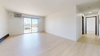 Located in Bismarck, North Dakota, this single-floor unit offers a well-organized layout across five distinct spaces, all unified by light-toned hardwood flooring and crisp white walls that create a clean, modern aesthetic throughout.

The expansive living area is a standout feature, anchored by a full-width sliding glass door that floods the room with natural light and provides views of the surrounding area. Black baseboard heating units run along the perimeter, offering efficient climate control suited to North Dakota's winters.

The kitchen is outfitted with warm wood cabinetry, a white range, and functional counter space, offering a practical and inviting cooking environment. Adjacent spaces provide flexibility for dining or additional living use.

The bedrooms are generously proportioned, each featuring wood-framed windows with horizontal blinds that allow for controlled natural light. One bedroom includes a walk-in closet and a warm-toned wood door, adding both storage and character. Baseboard heaters are present in each room for consistent warmth.

The bathroom is well-appointed with a wood-toned vanity cabinet, a rounded mirror with black hardware accents, a combination tub and shower, and a bright overhead light bar, delivering a polished and functional finish. The consistent light hardwood flooring extends throughout, tying the entire space together with a cohesive, contemporary feel.