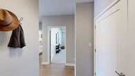 Located at 205 W Touhy Ave in Park Ridge, IL, this well-appointed two-bedroom, two-bathroom residence offers a thoughtfully designed single-floor layout. The open-concept living area is bright and welcoming, with large windows and a glass door that flood the space with natural light and provide views of the surrounding greenery. Hardwood-style flooring runs throughout the main living areas, adding warmth and continuity.

The modern kitchen is a standout feature, outfitted with white shaker cabinetry, a gray tile backsplash, sleek quartz countertops, and a full suite of stainless steel appliances including a gas range, microwave, dishwasher, and refrigerator. A peninsula with bar seating bridges the kitchen and living area, making it ideal for entertaining.

Both bedrooms are carpeted and feature ceiling fans, ample natural light from exterior-facing windows, and walk-in closets with wire shelving systems offering generous storage. The primary bedroom is spaciously sized and benefits from direct sightlines to the kitchen.

The two bathrooms are finished in a clean, neutral palette. One features a full tub-shower combination with chrome fixtures and hardwood-style flooring. The layout also includes multiple hallways and additional closet storage, ensuring practical organization throughout the residence.