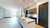 Located at 5126 Peachtree Blvd in Chamblee, Georgia, this single-floor residence showcases a thoughtfully designed, contemporary interior with a cohesive blend of modern finishes and functional living spaces. The open-concept kitchen is a standout feature, anchored by an expansive white quartz island with an undermount sink and stylish pendant lighting. Warm wood-grain upper cabinetry contrasts beautifully with dark lower cabinets, while stainless steel appliances — including a refrigerator, microwave, and range — complete the chef-ready setup. The kitchen flows seamlessly into a bright, open living area with light hardwood-style flooring and large sliding glass doors that invite abundant natural light and provide access to a private balcony with open views. Bedrooms are finished with plush carpeting, crisp white walls, and dark-trimmed doors, with walk-in closet access visible in one room. The primary bathroom impresses with a glass-enclosed walk-in shower, a separate soaking tub, wood-finish vanity with dual sinks, and light hardwood flooring. A second full bathroom features a tub-shower combo and built-in open shelving. A dedicated in-unit laundry closet with a stacked washer and dryer adds everyday convenience. Dark-framed interior doors and consistent trim details lend a polished, modern character throughout.