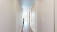 Located in the heart of downtown Nashville on Church Street, this one-bedroom, one-bathroom residence delivers a modern urban living experience with refined finishes and impressive city views. The layout flows from a well-proportioned hallway — lined with clean white walls and wood-look flooring — into the main living areas.

The living room is a standout space, featuring dramatic floor-to-ceiling windows that frame sweeping views of the Nashville skyline, flooding the room with natural light. An exposed concrete ceiling adds an industrial character, complemented by a ceiling fan and warm hardwood-style flooring.

The kitchen is efficiently designed with stainless steel appliances, white cabinetry, a classic subway tile backsplash, and striking granite countertops that extend to a breakfast bar — offering both functionality and style.

The spacious primary bedroom continues the industrial-modern aesthetic with an exposed concrete ceiling, generous natural light, and hardwood-style flooring. The bathroom features tile flooring, a granite-topped vanity, and clean, neutral finishes.

A dedicated closet and hallway complete the thoughtful layout. Throughout the residence, the consistent use of wood-look flooring, crisp white walls, and concrete ceiling details creates a cohesive, contemporary ambiance ideal for urban living in Nashville.