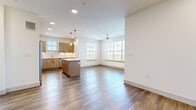 Located in Dripping Springs, TX, this single-story, 3-bedroom, 2-bathroom home offers a well-designed layout with modern finishes throughout. Wood-look flooring flows seamlessly across every room, complemented by crisp white walls and clean baseboards that give the home a bright, contemporary feel.

The open-concept living area combines the kitchen, dining, and living spaces into one expansive, light-filled great room. Large windows allow abundant natural light, while ceiling fans enhance comfort. The kitchen is a standout feature, boasting light wood cabinetry with matte black hardware, white quartz countertops, a classic subway tile backsplash, a central island with pendant lighting, and a full suite of stainless steel appliances including a range, microwave, and dishwasher.

The primary bedroom is generously sized and connects to a well-appointed en-suite bathroom featuring a wood-tone vanity with a white countertop, a glass-enclosed shower, and direct access to a walk-in closet with built-in shelving and hanging rods. Additional bedrooms are bright and open, each with ample closet space. A dedicated in-unit laundry room houses a full-size washer and dryer. The home also includes a utility room, multiple hallways, and a total of five closets, ensuring exceptional storage throughout.