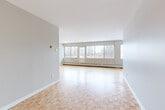 Located at 5500 Avenue Borden in the established neighbourhood of Côte-Saint-Luc, this 2-bedroom, 1-bathroom unit offers a well-organized layout with a welcoming entrance that flows into a spacious hallway connecting the main living areas. The living room is the centerpiece of the unit, featuring classic parquet flooring and a wide bank of large windows that flood the space with natural light and frame views of the surrounding treetops and neighbourhood. This open, airy quality carries throughout the unit. The kitchen is efficiently designed with white cabinetry, a subway tile backsplash, dark countertops, and white appliances including a range and dishwasher, all set on light tile flooring. The primary bedroom is generously sized, offering parquet floors, a large window with outdoor views, and its own wall-unit air conditioning. The second bedroom also features parquet flooring and a full closet with bi-fold doors, making it well-suited as a guest room or home office. The bathroom is clean and functional, complete with white tile surrounding a full bathtub and shower, a white vanity, and light tile flooring. Throughout the unit, neutral grey walls and consistent parquet flooring create a cohesive, bright, and move-in-ready atmosphere.
