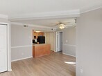 Located at 1061 Johnnie Dodds Blvd in Mount Pleasant, SC, this single-floor, 2-bedroom, 2-bathroom residence offers a thoughtfully laid-out floor plan with a clean, neutral aesthetic throughout. The open living area is finished with light-toned luxury vinyl plank flooring, crisp white crown molding, and soft gray walls that create a bright and welcoming atmosphere. A large bay window floods the space with abundant natural light, while sliding glass doors provide direct outdoor access. A ceiling fan adds comfort to the living area.

The kitchen features warm wood-toned cabinetry, granite-look countertops, a peninsula breakfast bar, and a full suite of black appliances including a range, dishwasher, and refrigerator — all set atop matching luxury vinyl plank flooring.

Both bedrooms are carpeted for comfort and include ceiling fans and windows with outdoor views of surrounding greenery. The well-sized primary bedroom offers a closet and a calm, neutral palette. Each bathroom is appointed with white tiled tub-and-shower combinations and clean, functional finishes.

This residence provides a practical and comfortable layout well-suited to everyday living in the heart of Mount Pleasant.