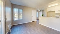 Located at 1455 E Date St in San Bernardino, CA, this one-bedroom, one-bathroom unit offers an efficient and thoughtfully arranged single-floor layout. Light-toned wood-look flooring runs throughout the space, creating a cohesive and clean aesthetic. The open-concept living and dining area is bright and welcoming, featuring vertical-blind windows that frame outdoor views of the surrounding landscape and allow natural light to fill the room. A ceiling fan adds comfort to the living area, which flows seamlessly toward the kitchen.

The kitchen is well-appointed with crisp white cabinetry offering generous storage, granite-style countertops, a stainless steel sink, and a white electric range. A breakfast bar peninsula separates the kitchen from the living and dining area, providing additional prep and casual dining space.

The bedroom is a comfortable size, featuring a closet with sliding doors, a large window with outdoor views, and the same wood-look flooring found throughout the unit. Two closets in total provide practical storage solutions.

The bathroom is clean and functional, finished with a full-size tub and shower combination, a white vanity, and neutral-toned walls. Textured ceilings are present throughout, adding a consistent architectural detail. Overall, the unit presents a tidy, move-in-ready environment ideal for single occupancy or a couple.