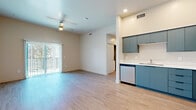 Located at 140 W 2nd Ave in Mesa, Arizona, this thoughtfully designed 2-bedroom, 2-bathroom residence offers a clean, modern aesthetic across a single-level floor plan. Light wood-style flooring flows seamlessly throughout every room, creating a cohesive and contemporary feel.

The open-concept living and kitchen area is a standout feature, where a well-appointed kitchen showcases distinctive teal cabinetry, stainless steel appliances including a range, microwave, dishwasher, and refrigerator, and bright white countertops. The living area benefits from a ceiling fan and access to an outdoor space via sliding glass doors fitted with vertical blinds, allowing for generous natural light.

The primary bedroom is a comfortable retreat featuring dual windows that invite natural light and views of the surrounding neighborhood. It includes a ceiling fan and a closet. The second bedroom also offers sliding glass door access to the outdoors, a ceiling fan, and a similarly bright, airy atmosphere.

Both bathrooms are finished in a modern style, featuring floating vanities with white countertops and wood-style flooring. One bathroom includes a walk-in shower, while the other is designed with a clean, minimalist layout. The overall ambiance of the space is bright, clean, and move-in ready, reflecting a contemporary design sensibility throughout.
