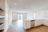 Located at 2718 N 118th St in Omaha, Nebraska, this well-appointed 2-bedroom, 2-bathroom unit offers a thoughtfully designed single-level layout. The open-concept kitchen and living area serves as the heart of the home, showcasing warm hardwood-style flooring, recessed lighting, and a seamless flow toward a private balcony with sliding glass doors that invite natural light throughout. The kitchen is outfitted with crisp white cabinetry, light quartz countertops, a central island with an undermount sink, and a full suite of stainless steel appliances including a refrigerator, range, microwave, and dishwasher. The spacious primary bedroom features plush carpeting, a ceiling fan, and direct access to a dedicated closet and a private en-suite bathroom. The second bedroom is equally comfortable, also finished with soft carpet and a ceiling fan, with access to natural light from an exterior-facing window. Both bathrooms are finished in a clean, modern palette with white vanities, quartz countertops, and hardwood-style flooring. A walk-in closet with built-in shelving adds generous storage. The overall design is bright and contemporary, with a neutral color scheme that creates a clean, move-in-ready ambiance throughout.