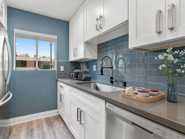 Blue tiled kitchen with stainless steel fridge and dish washer. - Catalina Apartments