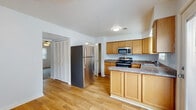 Located at 152 Kimber Ln in Evansville, Indiana, this two-story home offers a practical and comfortable layout across two levels. The kitchen is a functional centerpiece, outfitted with warm honey-toned cabinetry, granite-look countertops, and a full suite of stainless steel appliances including a refrigerator, electric range, built-in microwave, and dishwasher. A double-basin sink sits beneath a window that lets in natural light, while a door provides direct access to an outdoor area. A dedicated pantry closet adds convenient storage. Hardwood-style flooring runs throughout the kitchen and main living areas, lending a cohesive, clean aesthetic. The bedrooms are carpeted for comfort, each featuring ceiling fans with light fixtures and windows with blinds that invite natural light. Closets with built-in rods provide ample storage in the sleeping quarters. Bathrooms are finished with hardwood-style flooring, wood-toned vanity cabinetry, and clean white fixtures. A dedicated laundry area houses a full-size front-loading washer and dryer set beneath upper cabinetry for added storage. The home's neutral color palette and straightforward design provide a versatile backdrop well-suited for a variety of living arrangements.