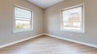 Located at 233 W Broadway in the heart of Louisville, KY, this 2-bedroom, 2-bathroom unit offers a practical and comfortable layout on a single floor. The open kitchen and living area features light hardwood-style flooring, light wood cabinetry, a full suite of white appliances including a refrigerator and range, and a window overlooking the surrounding cityscape, allowing natural light to fill the space throughout the day. The living area flows naturally from the kitchen, showcasing the same light flooring and vaulted ceilings that lend a sense of openness and height to the shared space. Both bedrooms are finished with soft neutral-toned carpet and feature windows with views of the Louisville skyline and neighborhood. The primary bedroom is a generously sized retreat equipped with two double-door closets, providing ample storage. The second bedroom is equally well-lit with a window and comfortable carpeting. The two bathrooms are finished with wood-style flooring; one features a shower stall with built-in shelving, while the other includes a full tub-shower combo with a vanity and light wood cabinetry. Throughout the unit, warm beige tones, white trim, and consistent finishes create a cohesive and welcoming atmosphere.