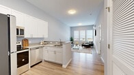 Located at 33 Old Tavern Rd in Orange, CT, this efficiently designed one-bedroom, one-bathroom residence offers a thoughtful open-concept layout across a single floor. Light hardwood flooring flows throughout the space, complemented by soft gray walls and crisp white trim that create a clean, modern aesthetic.

The kitchen and living area form a seamless open plan. The kitchen is outfitted with white shaker-style cabinetry, light stone countertops, a peninsula with an undermount sink, and a full suite of stainless steel appliances including a refrigerator, range, microwave, and dishwasher. The adjoining living area is bright and airy, anchored by a bank of large windows that invite natural light and provide outdoor views. A wall-mounted TV and a ductless mini-split unit complete the living space.

The bedroom is a comfortable, well-lit retreat featuring a trio of large windows and continued hardwood flooring. It is complemented by a dedicated walk-in closet with full wire shelving systems offering generous storage capacity.

The bathroom features tile flooring, a gray shaker-style vanity with a white countertop, a large mirror, and modern fixtures, delivering a polished and functional finish. The overall design of the residence is contemporary and cohesive, emphasizing clean lines and practical living.