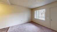 Located at 820 S E Street in Oxnard, California, this one-bedroom, one-bathroom unit offers a functional and efficient single-floor layout. The living room features soft carpeting, a textured popcorn ceiling, a ceiling fan, and a wall-mounted heater unit, creating a comfortable and practical space. Natural light filters in through a window fitted with vertical blinds, offering a view of the surrounding greenery. The entry area leads seamlessly into the living space, maintaining an open and accessible flow throughout the unit. The combined dining and kitchen area features hard-surface flooring, providing a practical contrast to the carpeted living and sleeping spaces. The bedroom is a well-proportioned room with plush carpet, neutral walls, a textured ceiling, and a window that brings in additional natural light. Two closets offer ample storage throughout the unit. The bathroom is clean and straightforward, equipped with a full-size soaking tub and shower combination featuring chrome fixtures. Throughout the unit, the warm beige tones on the walls and neutral finishes create a cohesive and understated aesthetic, making it easy to personalize the space.