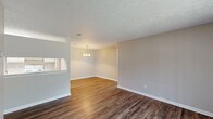 Located at 5300 Woodruff Farm Rd in Columbus, GA, this single-floor, three-bedroom, two-bathroom home offers a practical and comfortable layout. The combined kitchen and dining area is a central hub of the home, featuring wood-look vinyl flooring, cream-toned cabinetry, light countertops, and white appliances including a refrigerator and dishwasher. An elegant chandelier illuminates the dining space, adding a refined touch to everyday meals. The three bedrooms are carpeted and finished in neutral tones, each benefiting from natural light via slatted window blinds. Ceiling fans are present in multiple bedrooms, enhancing comfort year-round. The spacious primary bedroom includes an attached closet, while additional closet storage is available elsewhere in the home. Both bathrooms are equipped with full tub/shower combinations framed by clean white surrounds and wood-look flooring. A balcony provides an outdoor retreat. Throughout the home, white trim and baseboards offer a clean contrast to the warm, neutral wall palette, creating a cohesive and move-in-ready aesthetic. The straightforward single-floor layout ensures easy accessibility and efficient use of space.