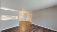 Located at 5300 Woodruff Farm Rd in Columbus, GA, this single-floor, three-bedroom, two-bathroom home offers a practical and comfortable layout. The combined kitchen and dining area is a central hub of the home, featuring wood-look vinyl flooring, cream-toned cabinetry, light countertops, and white appliances including a refrigerator and dishwasher. An elegant chandelier illuminates the dining space, adding a refined touch to everyday meals. The three bedrooms are carpeted and finished in neutral tones, each benefiting from natural light via slatted window blinds. Ceiling fans are present in multiple bedrooms, enhancing comfort year-round. The spacious primary bedroom includes an attached closet, while additional closet storage is available elsewhere in the home. Both bathrooms are equipped with full tub/shower combinations framed by clean white surrounds and wood-look flooring. A balcony provides an outdoor retreat. Throughout the home, white trim and baseboards offer a clean contrast to the warm, neutral wall palette, creating a cohesive and move-in-ready aesthetic. The straightforward single-floor layout ensures easy accessibility and efficient use of space.