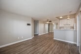 Located at 319 Imperial Beach Boulevard in the coastal city of Imperial Beach, California, this two-bedroom, two-bathroom residence offers a well-designed single-floor layout. The open-concept living, dining, and kitchen area forms the heart of the home, unified by warm wood-look vinyl flooring and neutral taupe wall tones that create a bright, cohesive ambiance. A ceiling fan overhead enhances comfort in the main living space, which receives natural light through a large front-facing window.

The kitchen is thoughtfully appointed with white shaker-style cabinetry, white appliances including a range and refrigerator, and a peninsula with a light countertop that provides additional prep space and serves as a casual dining area. Mirrored sliding closet doors in the adjacent area reflect light and add a sense of depth to the space.

Both bedrooms are comfortably sized and finished with plush carpeting, allowing for a cozy retreat from the living areas. Each room is naturally lit by windows with horizontal blinds. The primary bedroom includes a wall-mounted thermostat control for personalized comfort. Four closets are distributed throughout the unit, offering generous storage.

The two bathrooms each feature a clean, white tub-shower combination with chrome fixtures, complemented by neutral wall finishes for a tidy, functional design.