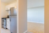 Located at 222 Nonquon Rd in Oshawa, Ontario, this three-bedroom, one-bathroom unit offers a practical and well-organized single-floor layout. The entrance opens into a hallway that connects the main living areas, creating a logical flow throughout the space.

The living room is a generous, light-filled area featuring classic parquet wood flooring and a large picture window that frames open city views, allowing abundant natural light to fill the room. A textured ceiling and baseboard heating are consistent features throughout the unit.

The kitchen has been thoughtfully updated with white shaker-style cabinetry, sleek bar-pull hardware, a white subway tile backsplash, and striking marble-patterned countertops. Stainless steel appliances, including a refrigerator and electric range, complete the space. The kitchen is finished with light ceramic tile flooring, which also carries through the entrance area.

All three bedrooms are finished with the same warm parquet flooring and neutral grey walls. Each room benefits from windows that bring in natural light and city views, with baseboard heaters positioned beneath the sills. The primary bedroom offers a comfortable footprint suitable for a full bedroom suite.

The bathroom is clean and functional, featuring a full-size soaker tub with a tiled surround, a curved shower rod, and light tile flooring, maintaining the unit's consistent neutral palette throughout.