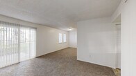 This single-floor, 2-bedroom, 2-bathroom home in Kansas City, Missouri offers a practical and comfortable layout designed for everyday living. The expansive living room is a standout feature, with wall-to-wall carpet, a sliding glass door that floods the space with natural light and provides outdoor access, and an additional set of windows that further brighten the open area. The kitchen is efficiently designed with white cabinetry, laminate countertops, tile flooring, and a full suite of appliances including an electric range, dishwasher, and refrigerator. Both bedrooms are carpeted and well-lit, featuring windows with blinds. The primary bedroom offers a generous footprint and includes a closet with louvered bifold doors and built-in shelving. The second bedroom also benefits from natural light via a horizontal window. Both bathrooms are clean and functional, featuring tile flooring, a vanity with storage, and a tub-shower combination with white tile surround. A hallway connects the main living areas, and a dedicated closet provides additional storage. Textured ceilings are consistent throughout the home, lending a classic, uniform aesthetic to every room.