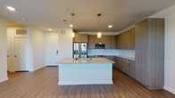Located in Dallas's vibrant 75206 zip code, this single-floor unit at 4912 San Jacinto St offers a thoughtfully designed layout with contemporary finishes throughout. The open-concept kitchen serves as the centerpiece of the living area, showcasing warm wood-toned cabinetry that extends to the ceiling for ample storage, a granite-topped island with an undermount sink, stainless steel appliances including a French door refrigerator, microwave, and range, complemented by a classic subway tile backsplash. Pendant lighting above the island adds a refined touch, while recessed lighting illuminates the space evenly. Wood-look plank flooring flows consistently throughout the unit, creating a cohesive and easy-to-maintain aesthetic. The living area benefits from natural light through large windows dressed with horizontal blinds, and a ceiling fan provides year-round comfort. The bedrooms are generously proportioned, each with clean white walls and the same durable plank flooring, with one room featuring a walk-in closet equipped with built-in hanging rods. The bathroom is finished with marble-patterned tile in the tub and shower surround, a granite-top vanity with wood cabinetry, and wood-look tile flooring, delivering a clean, spa-inspired feel. The overall ambiance is modern, bright, and move-in ready.