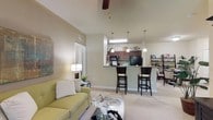 This single-story residence at The Park at Southwood offers a thoughtfully designed open-concept layout that seamlessly connects the living, dining, and kitchen areas. The living room features soaring ceilings, a ceiling fan, and plush carpeting, with a sliding glass door that invites natural light and outdoor access. A raised breakfast bar with bar seating bridges the kitchen and living space, while the kitchen itself is equipped with rich dark cabinetry, granite-style countertops, black appliances including a gas range, and wood-look flooring. Pendant lighting overhead adds a polished touch.

The primary bedroom is generously sized with a ceiling fan, multiple windows, a bold accent wall, and a dedicated walk-in closet with built-in shelving. A second bedroom offers similar comfort with natural light and a ceiling fan. Both bathrooms feature dark wood vanities with granite-style countertops, wood-look flooring, and tub-shower combinations. One bath is conveniently accessible directly from a bedroom. A dedicated laundry area houses a full-size side-by-side washer and dryer. Throughout the residence, neutral tones and consistent finishes create a cohesive and welcoming ambiance.