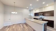 Located at 540 Park Ave in Clovis, CA, this two-story, 2-bedroom, 2-bathroom home offers a well-designed layout across two floors. The main living level hosts an open-concept space combining the living room, dining area, and kitchen. The kitchen is outfitted with dark espresso cabinetry, granite countertops, stainless steel appliances including a gas range and built-in microwave, and a breakfast bar peninsula. Light wood-style flooring runs throughout this level, complemented by recessed lighting and a chandelier above the dining area. The living room features vaulted ceilings, a ceiling fan, and sliding glass doors that open to a private balcony. A pantry and dedicated laundry area add everyday convenience. Carpeted stairs lead to the upper level, where both bedrooms are found. The primary bedroom benefits from vaulted ceilings and natural light from a large window, while the en-suite bathroom includes a double-sink granite vanity with dark cabinetry. The second bathroom also features a granite vanity. Five closets throughout the home provide generous storage. The entry level includes a utility room and direct staircase access, completing this thoughtfully laid-out home.
