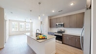 Located on Davis Rock Drive in Dacula, Georgia, this single-story, three-bedroom, four-bathroom home offers a well-designed layout with modern finishes throughout. Light wood-tone flooring flows consistently across the living areas and bedrooms, creating a cohesive and clean aesthetic.

The kitchen serves as a central hub, featuring rich dark wood cabinetry, a classic white subway tile backsplash, stainless steel appliances, and a large center island topped with granite countertops. Pendant lighting above the island adds a refined touch, while recessed lighting ensures the space is well-lit.

The living area is bright and inviting, with large windows fitted with blinds that allow natural light to pour in. Each of the three bedrooms includes a ceiling fan and generous windows with outdoor views of the surrounding neighborhood. Closet space is well-appointed, with wire shelving systems providing organized storage. The spacious primary bedroom offers a comfortable retreat with its own closet access.

The four bathrooms are finished with clean white subway tile surrounds, soaking tubs, granite-topped vanities with dark wood cabinetry, and light wood flooring, maintaining the home's consistent and polished design language throughout. Two dedicated closets further enhance the home's practical storage capacity.