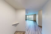 Located at 1111 E Union St in Seattle's Capitol Hill neighborhood, this one-bedroom, one-bathroom unit offers a well-designed, efficient layout across a single floor. Light-toned luxury vinyl plank flooring runs throughout, lending the space a clean, modern aesthetic.

The open-concept kitchen and living area serves as the heart of the unit. The kitchen is equipped with stainless steel appliances — including a range, microwave, and dishwasher — complemented by rich dark wood cabinetry and light countertops. The living area features a large picture window that fills the space with natural light and frames views of the surrounding Seattle streetscape.

The bedroom is a comfortable, well-proportioned room with its own large window offering additional city views. It connects directly to a walk-in closet, providing generous storage. A second closet elsewhere in the unit adds further organizational flexibility.

The bathroom features a full tub-shower combination, a dark wood vanity with a light countertop, and consistent LVP flooring that ties it seamlessly to the rest of the unit. A dedicated laundry area and a connecting hallway round out the floor plan. The unit also includes a small built-in shelf near the entry, ideal as a drop zone. Overall, the space presents a bright, contemporary feel well-suited to urban living.