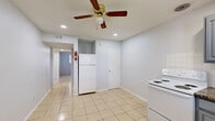 Located at 1742 Woodvine in Houston's 77055 zip code, this single-story, one-bedroom, one-bathroom residence offers a practical and efficient layout designed to maximize every square foot. Light-toned ceramic tile flooring runs consistently throughout the entire space, creating a clean, cohesive aesthetic that is easy to maintain.

The kitchen is well-appointed with gray raised-panel cabinetry, dark granite-style countertops, a stainless steel sink, a white electric range, and a classic white tile backsplash. A window above the sink allows natural light to brighten the workspace, while a ceiling fan and recessed lighting provide additional comfort and illumination.

The spacious bedroom comfortably accommodates standard furnishings and features a wide window that frames views of the surrounding greenery, filling the room with natural light. A ceiling fan adds to the room's comfort. A dedicated closet adjacent to the hallway provides organized storage.

The bathroom is outright and functional, featuring a full-size soaking tub with an overhead showerhead and chrome fixtures set against crisp white surroundings. The overall palette of the home — soft grays, whites, and warm tile tones — gives the space a clean and neutral ambiance, making it a versatile canvas ready for personalization.