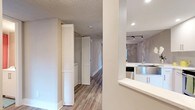 This single-floor space showcases a thoughtfully updated interior with a cohesive, contemporary aesthetic throughout. The kitchen is a standout feature, outfitted with crisp white shaker-style cabinetry extending to the ceiling, bright white quartz countertops, a stainless steel farmhouse sink, and a full suite of stainless steel appliances including a refrigerator, electric range with over-the-range microwave, and dishwasher. A subway tile backsplash adds a clean, modern touch, while recessed lighting and track lighting ensure the space is well-illuminated. The kitchen opens to the living area via a pass-through counter, creating a connected, open-concept flow ideal for entertaining.

The living area is generously proportioned, featuring light wood-look flooring, soft neutral-toned walls, and a ceiling fan with integrated lighting. Track lighting supplements the natural light that streams in through a sliding glass door, which provides direct access to a green outdoor area. The bedroom continues the light, airy palette with matching flooring, a ceiling fan, and a large window with blinds. Louvered closet doors are visible along the hallway, offering practical storage. Textured ceilings are present throughout, adding a subtle architectural detail to the overall design.