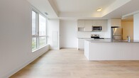 Located at 202 Burnhamthorpe Rd E in Mississauga, this contemporary 3-bedroom, 2-bathroom residence offers a well-designed open-concept layout with clean, modern finishes throughout. Light-toned hardwood-style flooring flows seamlessly across the entire unit, complementing the bright white walls and creating a cohesive, airy aesthetic.

The open-concept kitchen and living area serves as the heart of the home, featuring sleek flat-panel cabinetry in warm neutral tones, stone countertops, stainless steel appliances including a full-size refrigerator and stove, and a central island with additional counter space. Floor-to-ceiling windows flood the kitchen and living room with natural light while offering sweeping views of the surrounding Mississauga skyline and green landscapes below. A balcony extends the living space outdoors.

The spacious primary bedroom is generously proportioned and benefits from a large window framing scenic outdoor views. Two additional bedrooms are well-sized with ample closet storage, including sliding-door closets. Two full bathrooms serve the unit — one featuring a glass-enclosed shower, modern vanity with stone countertop, and large mirror, while the second is equally well-appointed with light tile flooring and a clean, minimalist design. A dedicated entry hallway completes this thoughtfully laid-out residence.