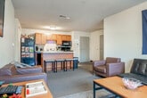 Located at 234 N Prince St in Whitewater, WI, this 2-bedroom, 4-bathroom single-floor unit offers a practical and well-organized layout. The open-concept kitchen and living area form the heart of the space, with the kitchen featuring warm wood cabinetry, black appliances including a range, microwave, and refrigerator, and a peninsula counter with bar seating — ideal for casual dining or socializing. Hardwood-style flooring runs through the kitchen, transitioning to carpet in the living and bedroom areas. The living room is generously sized, with large windows that bring in natural light and offer views of the surrounding landscape, creating an airy, comfortable atmosphere. Each of the two bedrooms is a cozy, private retreat with its own window providing natural light and outdoor views. The primary bedroom offers enough space for a bed, desk, and storage. The four bathrooms are a standout feature of this unit; one includes a wide double-sink vanity with rich wood cabinetry, a large mirror, and a separate shower area, providing ample space and functionality. The overall layout maximizes utility, with accessible common areas and private quarters that suit a shared living arrangement well.