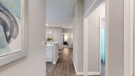 Located in Atlanta, GA, this single-floor, 2-bedroom, 2-bathroom residence offers a practical and comfortable layout with modern finishes throughout. The open-concept living and dining area is anchored by warm hardwood-style flooring and neutral tones, creating a bright, welcoming atmosphere. A distinctive architectural column adds character to the living room, which benefits from natural light streaming through large windows. The dining area sits adjacent to the kitchen and features a pass-through window that enhances connectivity between spaces. The kitchen is outfitted with ample white cabinetry, white appliances, tile backsplash, and generous counter space. Both bathrooms include tub-shower combinations with hardwood-style flooring for easy maintenance. The primary bedroom is a spacious retreat with plush carpeting, dual windows, and room for a full bedroom suite. The second bedroom, also carpeted and naturally lit, offers flexibility as a guest room or additional living space. A central hallway with two closets provides practical storage. The overall aesthetic throughout is clean and contemporary, with consistent neutral tones and cohesive design elements that make the space feel polished and move-in ready.