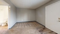 Located at 9600 E Girard Ave in Denver, CO, this efficiently designed single-floor unit makes smart use of its intimate footprint. The combined living and dining area serves as the heart of the space, featuring neutral-toned carpet, gray walls with blue-toned baseboards, a textured ceiling, and a wall-mounted HVAC unit situated beneath a window that brings in natural light and neighborhood views.

The kitchen is thoughtfully updated with white shaker-style cabinetry, granite countertops, a subway tile backsplash, and wood-look vinyl flooring. Black appliances — including a range, refrigerator, and dishwasher — provide a sleek contrast to the bright cabinetry, and an under-cabinet range hood adds functional detail.

The bathroom features a clean, all-white aesthetic with a full tub and shower combo dressed in white tile, wood-look flooring, and simple chrome fixtures — creating a crisp, utilitarian feel.

Three closets throughout the unit offer generous storage relative to its size. The consistent use of neutral tones, updated finishes, and practical layouts throughout give this unit a cohesive and functional character well-suited for streamlined urban living in Denver's east side.