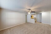 Located in Tomball, TX, this 2-bedroom, 2-bathroom residence offers a functional single-story layout thoughtfully designed for comfortable everyday living. The open-concept living room and kitchen area serves as the heart of the home, with plush wall-to-wall carpeting, neutral tones, and a ceiling fan with light kit providing a welcoming atmosphere. A window at the front allows natural light to fill the space. The kitchen is well-appointed with white shaker-style cabinetry, granite countertops, a stainless steel sink, and a full suite of stainless steel appliances including a range, microwave, refrigerator, and dishwasher. Wood-look flooring runs through the kitchen, adding warmth and easy maintenance. The primary bedroom is generously sized, featuring carpet flooring, a ceiling fan, and a window with outdoor views. The second bedroom is equally comfortable, also carpeted and equipped with a ceiling fan. A dedicated closet provides additional storage. Both bathrooms are appointed with tub/shower combinations finished in elegant marble-look wall surrounds with brushed nickel fixtures, lending a polished feel. The textured ceilings and clean white trim are consistent throughout, creating a cohesive and well-maintained interior.