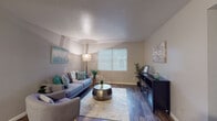This single-story residence offers a well-organized layout designed for comfortable everyday living. The living room serves as the heart of the space, featuring wood-look flooring, a textured ceiling, and a large window fitted with blinds that allows natural light to fill the room. A vaulted ceiling detail adds dimension to the area, enhancing its open feel.

The kitchen is efficiently arranged with white cabinetry, dark countertops, a double stainless steel sink, and black appliances including a range and oven. The galley-style configuration maximizes workspace and storage in a compact footprint.

Adjacent to the kitchen, the dining area features wood-look flooring, a ceiling fan with light fixture, and sliding glass doors that connect to the living room, creating a cohesive and flowing common area.

The two bedrooms offer plush carpeted flooring, ceiling fans, and windows with blinds. One bedroom provides a more expansive feel, while the second offers a quiet, versatile space suitable for various uses.

Both bathrooms are finished with dark granite-style countertops, white vanity cabinetry, framed mirrors, and textured walls. One bathroom includes a shower-tub combination, while the other features a compact vanity setup. Wood-look flooring ties the bathrooms together with the rest of the unit's cohesive aesthetic.
