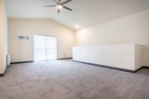 Located at 815 Commons Cir in Plover, Wisconsin, this two-story home offers a practical and comfortable layout across two floors. The main living level hosts an open-concept kitchen and living room, where rich dark-stained cabinetry, granite-look countertops, and stainless steel appliances—including a range, microwave, and refrigerator—define a functional kitchen. The living area features plush carpeting, vaulted ceilings, a ceiling fan, and a sliding glass door that opens to a private patio, allowing ample natural light to fill the space. A dedicated laundry room with a full-size front-loading washer and dryer adds everyday convenience on the same floor. Two carpeted bedrooms provide comfortable retreats; the primary bedroom is generously sized with vaulted ceilings and a window overlooking the surroundings. The full bathroom includes a soaking tub/shower combination and wood-look flooring. Two closets offer additional storage throughout. Carpeted staircases with clean white railings connect the floors. The attached garage, accessible from the lower level, provides secure parking and extra storage space. Neutral warm tones and consistent finishes throughout give the home a cohesive, move-in-ready feel.
