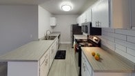 This single-floor unit offers a practical and well-organized layout designed to maximize functionality. The open-concept living area serves as the heart of the space, featuring wood-look laminate flooring, neutral gray walls, and a textured ceiling. Natural light filters in through a large sliding glass door fitted with vertical blinds, while a ceiling fan adds to the room's comfort. The kitchen is situated adjacent to the living area and is accessible via a peninsula counter that doubles as a casual dining surface. Designed in a galley style, the kitchen features white cabinetry, laminate countertops, a tiled backsplash, and stainless steel appliances, including a refrigerator, microwave, and an electric range.

Two bedrooms offer quiet retreats, each finished with plush carpet, neutral-toned walls, a textured ceiling, and windows with vertical blinds that admit natural light. The unit includes two bathrooms: one full bath equipped with a tub-shower combination, wood-look flooring, and clean white finishes, and a second bath featuring a spacious vanity with a wide mirror, ample counter space, and white cabinetry. A private water closet provides an additional layer of separation. Throughout, the unit maintains a clean, understated aesthetic with consistent neutral tones and updated fixtures.