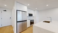 Located at 6070 Almon St in Halifax, NS, this thoughtfully designed two-bedroom, two-bathroom residence offers a clean, contemporary aesthetic across a single well-organized floor. Light hardwood flooring flows seamlessly throughout the open-concept living areas, complementing the crisp white walls and recessed lighting that create a bright, airy atmosphere.

The kitchen is a standout feature, showcasing high-gloss white cabinetry extending nearly to the ceiling for generous storage, stainless steel appliances including a French door refrigerator, built-in oven, and over-the-range microwave. A marble-finished island with an undermount sink serves as both a functional workspace and a visual centerpiece.

The living area benefits from floor-to-ceiling windows and sliding glass doors opening to a balcony, flooding the space with natural light and offering sweeping views of the Halifax cityscape. The primary bedroom continues this theme with expansive glazing and panoramic outdoor views.

The primary bathroom is a refined retreat, featuring a freestanding soaker tub alongside a glass-enclosed walk-in shower, all finished in neutral, marble-toned tile. A dedicated closet and two hallways add practical storage and smooth connectivity between rooms, rounding out this polished, modern residence.