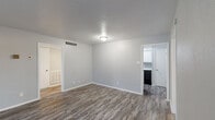 Located at 531 S Belt Line Rd in Grand Prairie, Texas, this single-story residence offers three bedrooms and two bathrooms across a well-utilized floor plan. Wood-look plank flooring runs throughout, providing a cohesive and easy-to-maintain aesthetic in every room.

The living room is open and bright, with neutral gray walls, a textured ceiling, and direct sightlines into the kitchen. The galley-style kitchen is efficiently designed with white cabinetry lining both sides, granite-look countertops, a stainless steel sink, and black appliances including an electric range and refrigerator, complemented by a range hood above.

The three bedrooms offer comfortable proportions, with the primary bedroom providing the most generous space. Bedrooms feature ceiling fans, wood-look flooring, and windows with blinds that allow natural light. One bedroom includes a closet with double doors, while another benefits from an outdoor-facing window view.

Both bathrooms are finished with white cabinetry, granite-look countertops, and tub/shower combinations featuring white tile surrounds and chrome fixtures. A hallway connects the rooms and includes additional closet storage. The overall color palette of soft grays and whites creates a clean, neutral ambiance throughout the home.