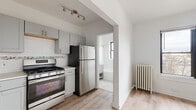Located at 636 W Melrose Street in Chicago's sought-after Lakeview neighborhood, this single-floor unit offers a clean, modern aesthetic with thoughtful updates throughout. The kitchen is a standout feature, outfitted with gray shaker-style cabinetry, stainless steel appliances including a gas range and full-size refrigerator, a subway tile backsplash accented by a decorative mosaic border, light quartz countertops, and an undermount sink. Track lighting overhead and light wood-style flooring add to the kitchen's contemporary feel. The living area is open and airy, with crisp white walls, a ceiling fan, and the same light wood-style flooring that runs throughout the unit, creating a cohesive and spacious feel. A closet provides convenient built-in storage. The bathroom maintains the home's clean palette with all-white tile, a soaking tub with shower combination, a window for natural light and ventilation, a gray vanity, and classic hex tile flooring. A cast-iron radiator is present, reflecting the building's classic Chicago character while providing reliable heat. The overall design balances modern finishes with functional, well-organized spaces, making this Lakeview unit a practical and attractive place to call home.