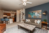 Located at 140 N Davis Rd in LaGrange, Georgia, this single-story residence offers a thoughtfully designed layout that balances comfort and functionality. The kitchen is a standout feature, showcasing rich warm-toned cabinetry, dark granite countertops, wood-look flooring, and a suspended pot rack overhead. Black appliances, including a full-size refrigerator and range, complement the space, while a bar-height counter provides additional seating. An adjacent dining area accommodates a round table beneath a classic chandelier. The living room is bright and welcoming, with carpeted flooring, a ceiling fan, and a glass-paned exterior door that allows natural light to flow in. The bedrooms are carpeted and serene, one featuring a bold accent wall and natural window light. Both bathrooms are finished with dark granite vanity tops, rich wood cabinetry, and wood-look flooring, with one bathroom offering access to a walk-in closet. A dedicated laundry room houses a full-size washer and dryer. Throughout, neutral warm tones create a cohesive and inviting ambiance across every room.