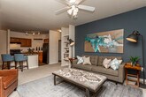 Located at 140 N Davis Rd in LaGrange, Georgia, this single-story residence offers a thoughtfully designed layout that balances comfort and functionality. The kitchen is a standout feature, showcasing rich warm-toned cabinetry, dark granite countertops, wood-look flooring, and a suspended pot rack overhead. Black appliances, including a full-size refrigerator and range, complement the space, while a bar-height counter provides additional seating. An adjacent dining area accommodates a round table beneath a classic chandelier. The living room is bright and welcoming, with carpeted flooring, a ceiling fan, and a glass-paned exterior door that allows natural light to flow in. The bedrooms are carpeted and serene, one featuring a bold accent wall and natural window light. Both bathrooms are finished with dark granite vanity tops, rich wood cabinetry, and wood-look flooring, with one bathroom offering access to a walk-in closet. A dedicated laundry room houses a full-size washer and dryer. Throughout, neutral warm tones create a cohesive and inviting ambiance across every room.