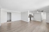 Located in Van Nuys, Los Angeles, this well-appointed 2-bedroom, 2-bathroom unit is spread across a single floor, offering a practical and comfortable layout. Light-toned laminate flooring runs throughout, creating a cohesive and clean aesthetic across all rooms.

The living room is a standout space, featuring floor-to-ceiling windows with vertical blinds that flood the area with natural light and provide views of the surrounding greenery. Crown molding and a ceiling fan add a polished touch to the room, which flows toward the kitchen.

The kitchen is efficiently designed with white shaker-style cabinetry, granite countertops, stainless steel appliances including a gas range, microwave, and dishwasher, and a double sink — offering both functionality and style.

The primary bedroom is generously sized with large windows that invite natural light, and features a full wall of mirrored sliding closet doors that enhance the sense of space. The second bedroom mirrors a similar layout with its own mirrored closet.

Both bathrooms are cleanly finished with light-colored walls, wood-look flooring, and white vanities. One bathroom includes a shower/tub combo with a window for ventilation, while the second provides additional convenience for guests or residents.