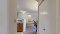 This single-floor, 2-bedroom, 2-bathroom residence in Windsor Mill, Maryland offers a practical and comfortable layout designed for everyday living. The kitchen features warm wood cabinetry, white appliances including a refrigerator, range, and dishwasher, light-toned countertops, and tile flooring, complemented by a sage green accent wall that adds a pop of color. A breakfast bar connects the kitchen to the dining and living areas, creating an open, cohesive flow. The dedicated dining area accommodates a full-sized table and is finished with carpeting and a ceiling fixture. The living room is bright and inviting, anchored by a sliding glass door that opens to an outdoor patio and provides views of the surrounding greenery. Both bedrooms are generously sized with plush carpeting and windows that draw in natural light. One bedroom features a large window framing outdoor views, while the other offers ample room for a full furniture arrangement. Each bathroom is well-equipped — one includes a vanity with wood cabinetry and a large mirror with overhead lighting, while the second features a full tub-shower combination with tile surround and tile flooring. Throughout the home, neutral tones and consistent finishes create a clean, cohesive aesthetic.