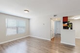 Located at 3901 Michael Blvd in Mobile, Alabama, this single-floor residence offers a clean, modern aesthetic throughout. The open living area is highlighted by warm hardwood-style flooring, neutral gray walls, and bright windows with blinds that allow natural light to fill the space. A pass-through connects the living area to the kitchen, creating an open and connected feel. The kitchen is well-equipped, featuring warm wood cabinetry, granite-style countertops, a double stainless steel sink, and black appliances including a refrigerator, electric range, and dishwasher. Ceiling-mounted lighting provides ample illumination throughout. The bedrooms continue the hardwood-style flooring and are each fitted with ceiling fans with light kits and windows that bring in natural light, creating comfortable, airy retreats. The bathroom is finished with a wood-toned vanity, granite-style countertop, a large mirror, and a tub-shower combination. Consistent use of neutral tones, white trim, and modern fixtures throughout the home creates a cohesive and inviting atmosphere, making this a practical and attractive residence in Mobile.